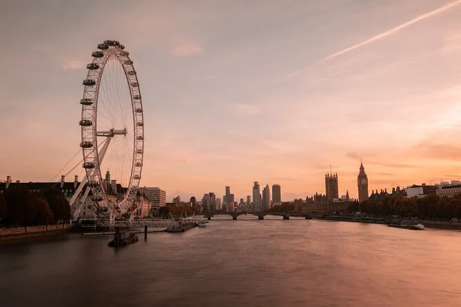 The London Eye and the Houses of Parliament with Big Ben at sunset, seen from upriver